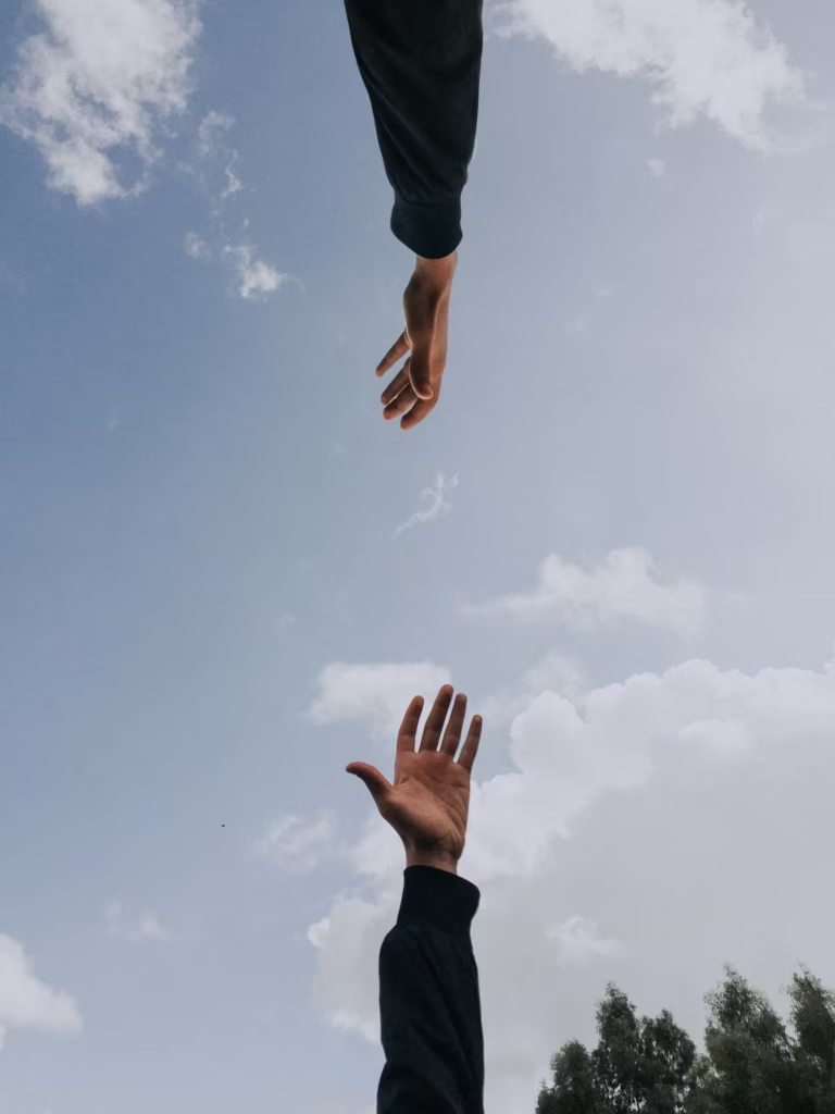 Two people in New Jersey reaching their hands out to each other in support of their recovery
