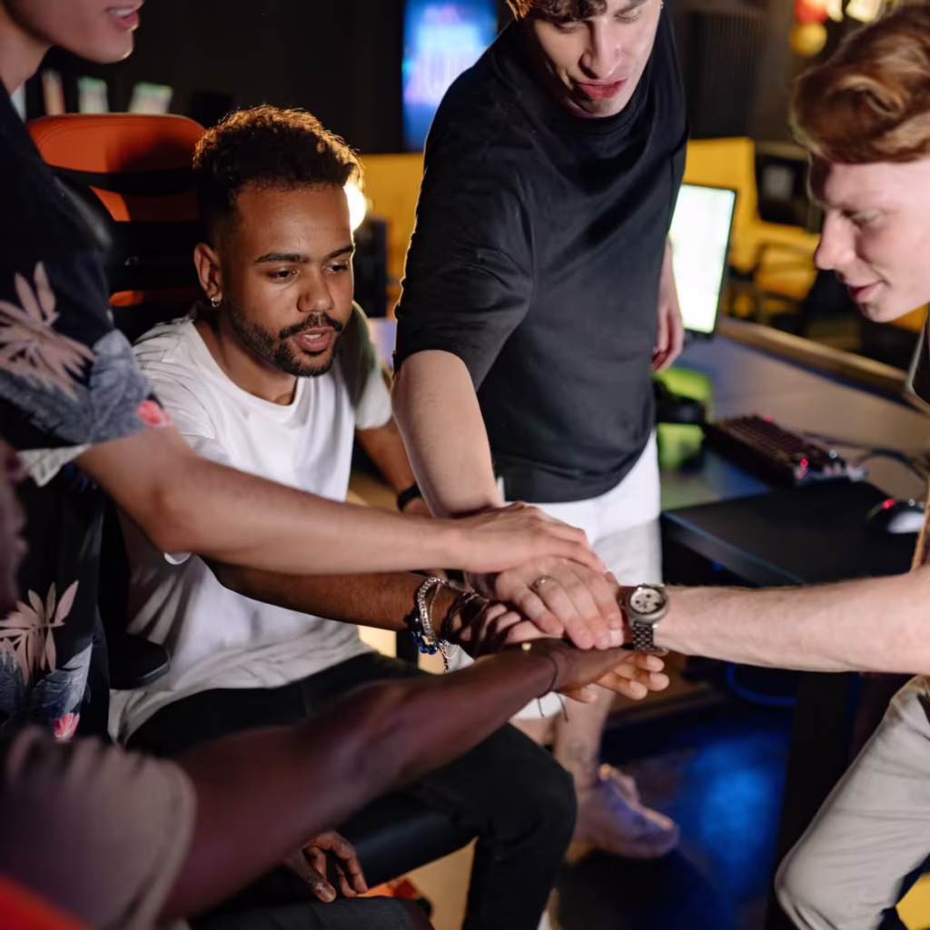 A group of people putting their hands in the middle of a circle at the start of their recovery program