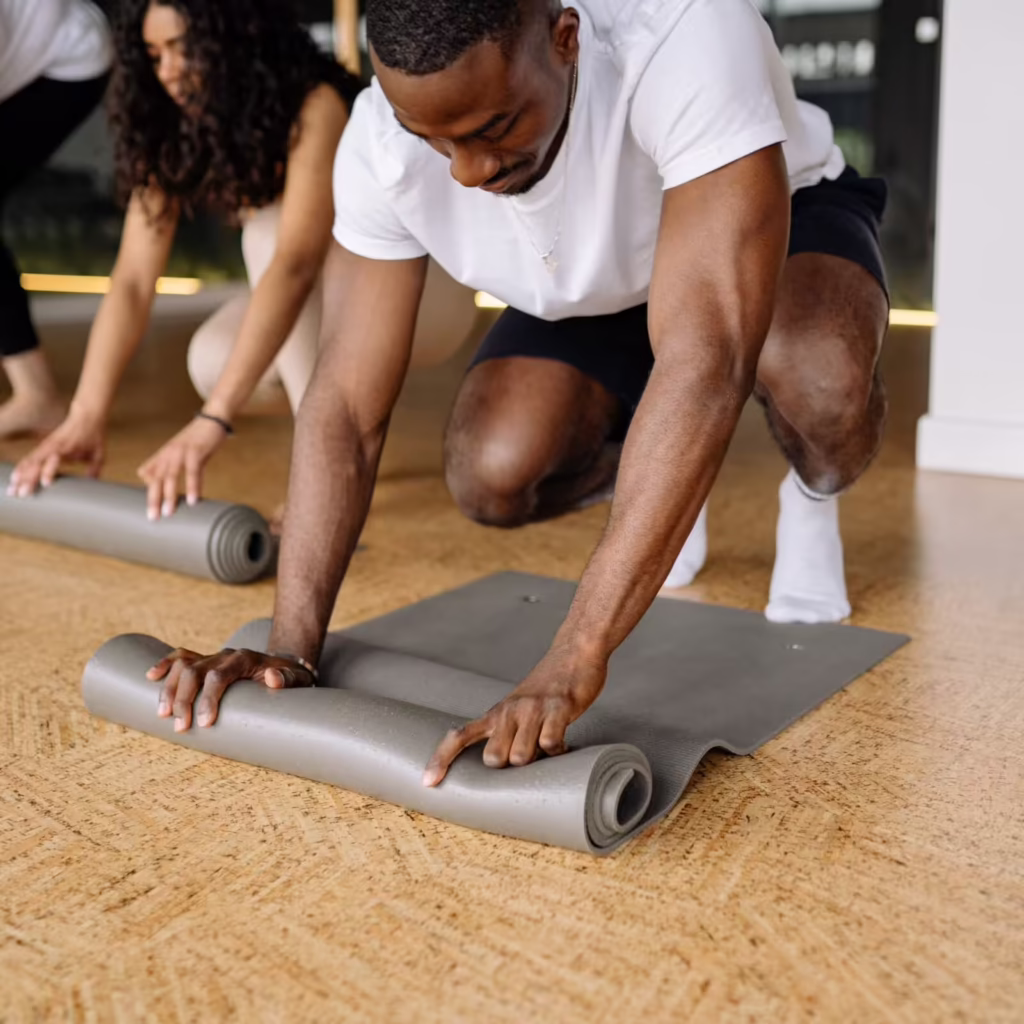 A group of people rolling out yoga mats for an addiction treatment session